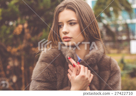 Pretty teen girl is wearing fur coat Pretty teen girl is wearing fur coat 27422710