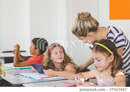 Teacher teaching kids on digital tablet Teacher teaching kids on digital tablet 27425947