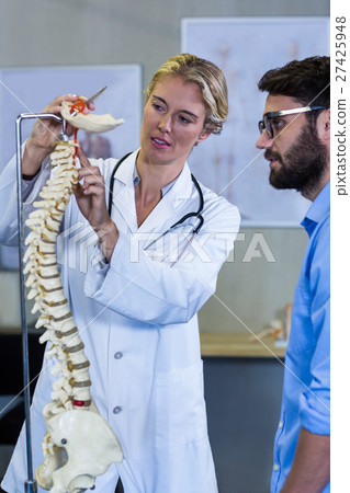 Physiotherapist explaining the spine model to patient Physiotherapist explaining the spine model to patient 27425948