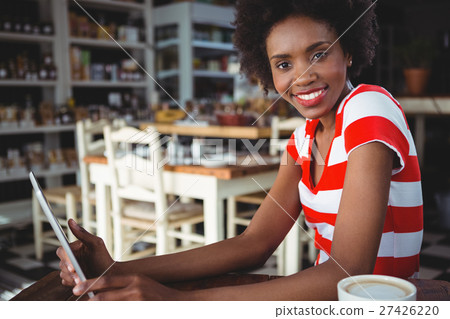 Smiling woman using digital tablet in cafe 27426220