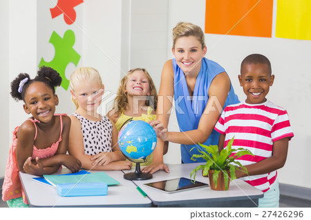 Teacher discussing globe with kids 27426296