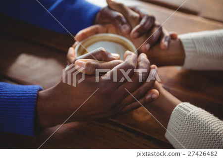 Couple holding hands while having coffee 27426482