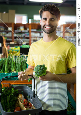 Portrait of handsome man buying broccoli and different vegetables in organic section Portrait of handsome man buying broccoli and different vegetables in organic section 27427188