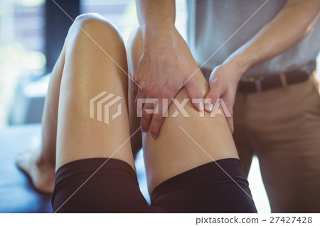 Physiotherapist giving leg massage to a woman 27427428