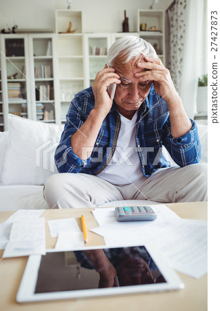 Tensed senior man talking on mobile phone Tensed senior man talking on mobile phone 27427873