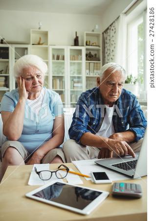 Worried senior couple using laptop Worried senior couple using laptop 27428186
