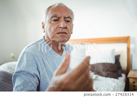 Senior man looking at pill bottle Senior man looking at pill bottle 27428314