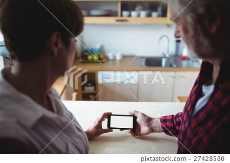 Senior couple using mobile phone Senior couple using mobile phone 27428580