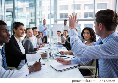 图库照片: colleague raising his hand during meeting