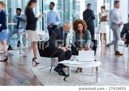 Businesspeople discussing over laptop 27428650
