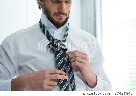 Man getting dressed in bedroom 27428845