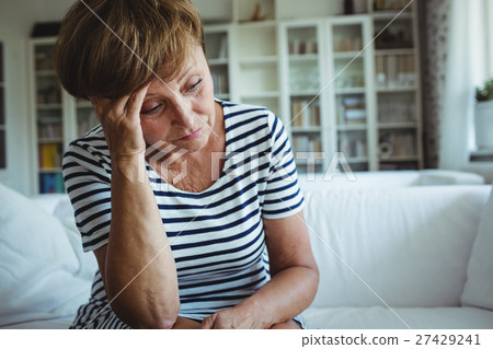 Tense woman sitting on sofa in living room 27429241
