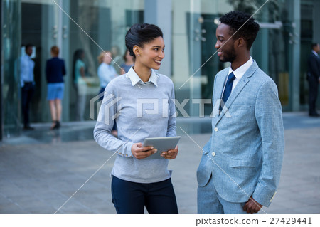 Businessman and colleague interacting in office building Businessman and colleague interacting in office building 27429441