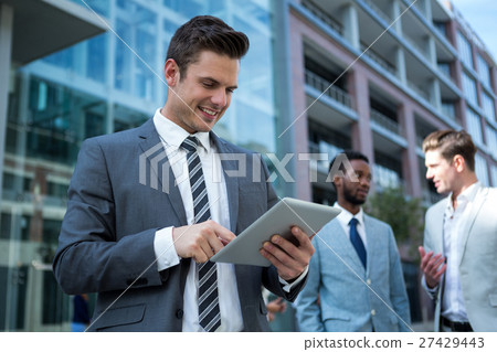 Businessman using digital tablet in the office building Businessman using digital tablet in the office building 27429443