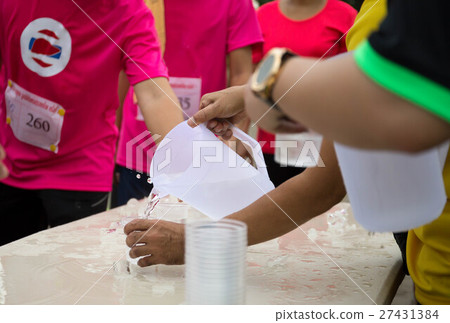 Volunteer pouring water for marathon runner Volunteer pouring water for marathon runner 27431384