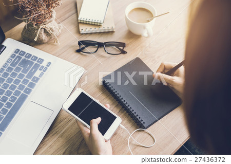 woman writing on notebook at workplace 27436372