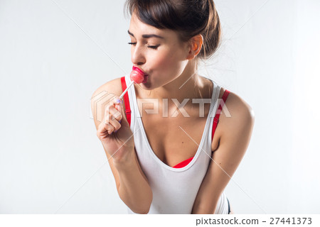 Young brunette model with lollipop posing studio Young brunette model with lollipop posing studio 27441373