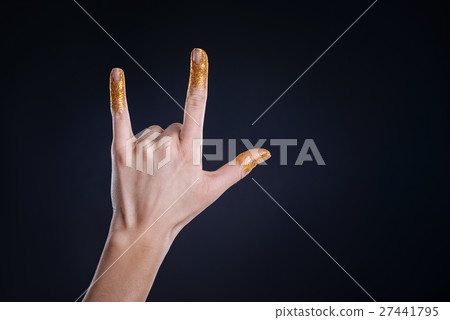 Hand covered with tinsels gesturing on black 27441795