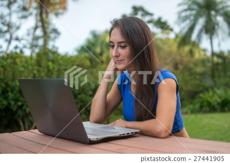 Cheerful girl watching online video on laptop 27441905