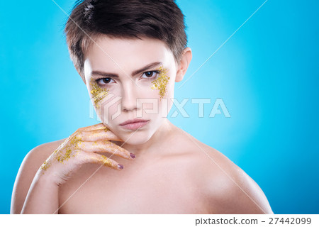Serious beautiful woman posing against blue Serious beautiful woman posing against blue 27442099