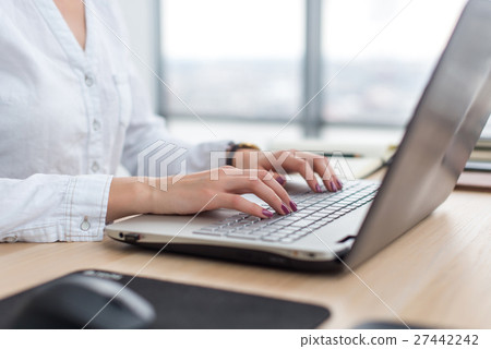 Office worker typing, working at her workplace Office worker typing, working at her workplace 27442242