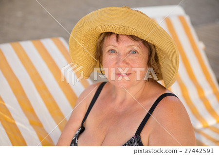 Smiling Senior woman wearing hat at beach on Smiling Senior woman wearing hat at beach on 27442591