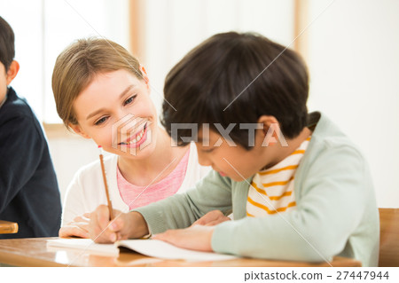 Female English Teacher Assisting A Young Student Female English Teacher Assisting A Young Student 27447944