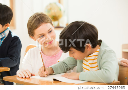 Female English Teacher Assisting A Young Student Female English Teacher Assisting A Young Student 27447965