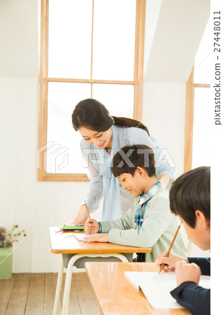 Female Teacher Assisting A Young Student 27448011