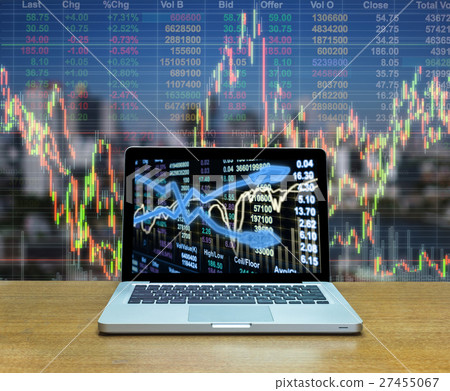 Stock exchange market trading graph over the screen of computer laptop on wood table over the photo blurred of trading graph background, business marketing trade concept 27455067