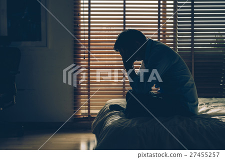 Sad businessman sitting head in hands on the bed in the dark bedroom with low light environment, dramatic concept, vintage tone color 27455257