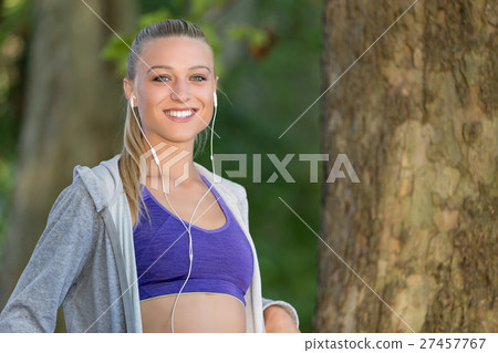 Young lady jogging on a park road having break and Young lady jogging on a park road having break and 27457767