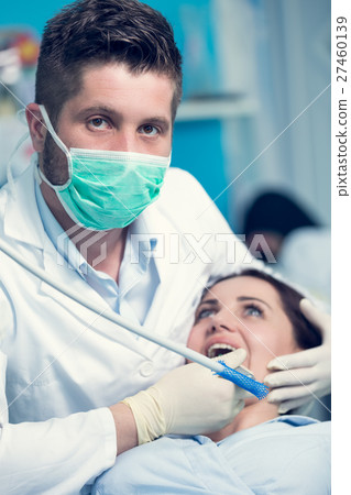 Dentist examining Patient teeth with a Mouth 27460139