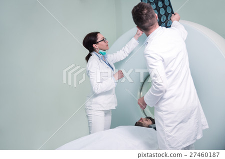 Mid adult nurse preparing patient for CT scan test 27460187