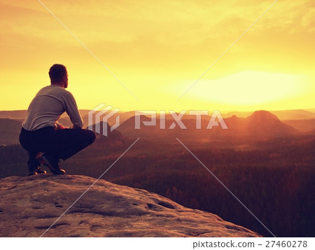 Adult in black sit on mountain edge. Man enjoyi 27460278