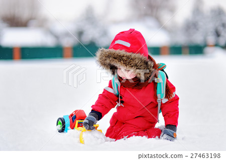Little boy playing with bright car toy and fresh snow 27463198