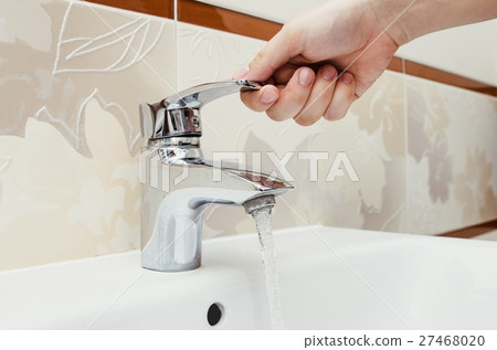 Man unscrew the faucet in the bathroom. Man unscrew the faucet in the bathroom. 27468020