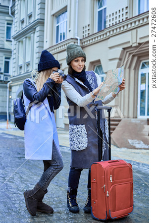 Two friends tourists choose attractions on the map 27472608
