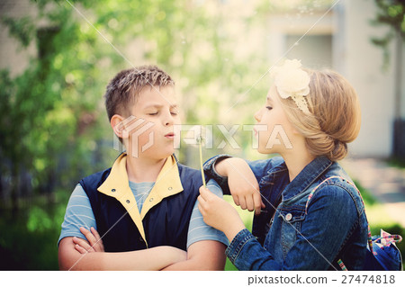 Young Boy and Girl Blowing a Dandelion Flowers Young Boy and Girl Blowing a Dandelion Flowers 27474818