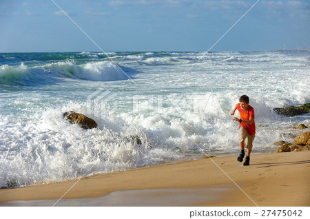 Boy runs along the seashore 27475042