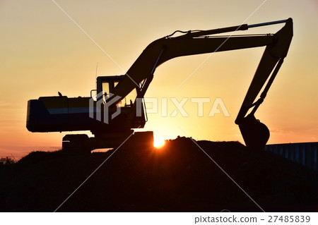 A silhouette excavator bathed in the setting sun A silhouette excavator bathed in the setting sun 27485839