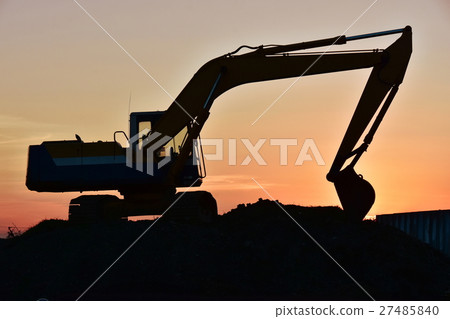 A silhouette excavator bathed in the setting sun 27485840