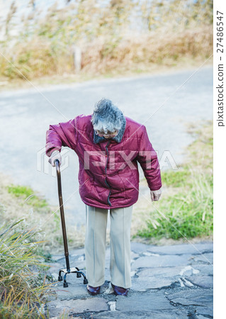 Senior woman climbing stairs with walking stick 27486547