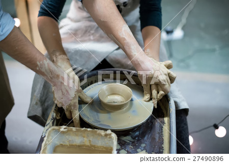 Hands working on pottery wheel Hands working on pottery wheel 27490896