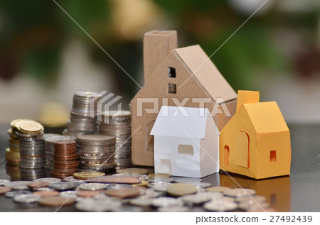 Paper house and stacks of coins standing Paper house and stacks of coins standing 27492439