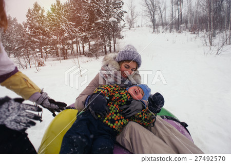Happy caucasian people hugging on snow tube 27492570