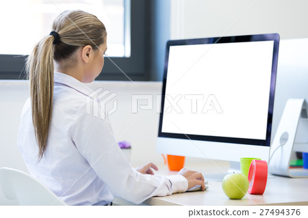 Woman working at computer in an office 27494376