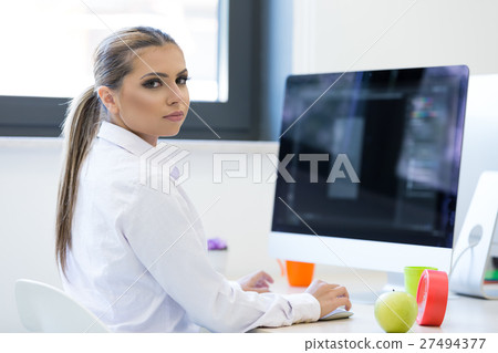 Woman working at computer in an office 27494377