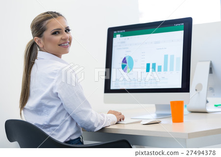 Woman working at computer in an office 27494378