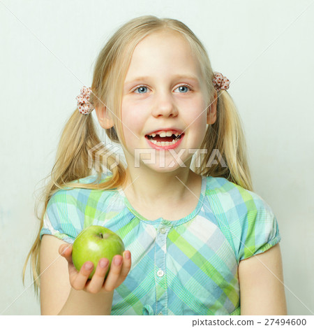 Laughing little girl with green apple Laughing little girl with green apple 27494600